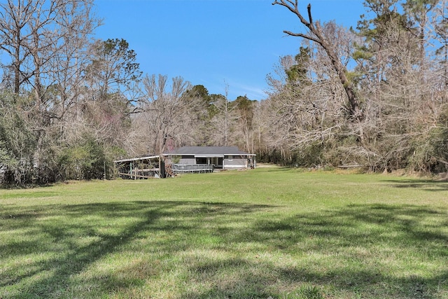 view of yard with a carport and a wooded view