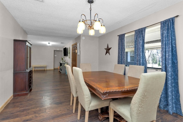 dining area with a chandelier, baseboards, a textured ceiling, and dark wood-style floors