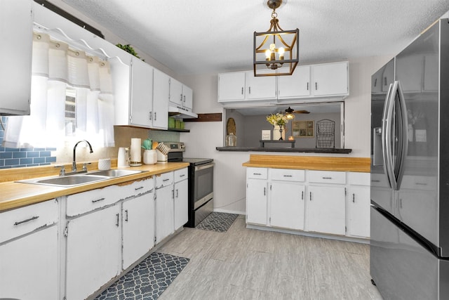 kitchen with white cabinets, ceiling fan with notable chandelier, appliances with stainless steel finishes, and a sink