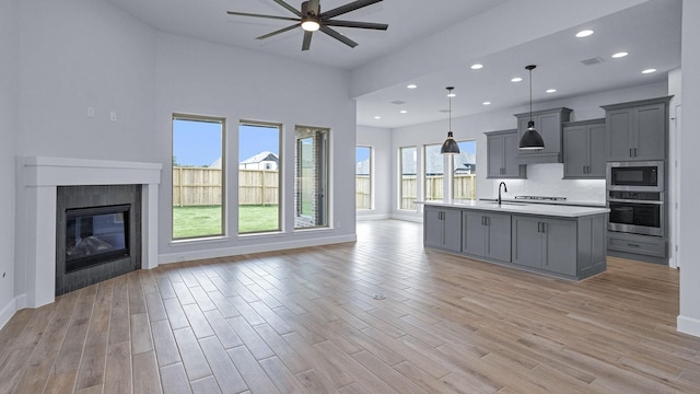 12247 Sweet Gum Dr, Mont Belvieu, TX 77523 - kitchen featuring appliances with stainless steel finishes, open floor plan, gray cabinetry, a ceiling fan, and recessed lighting