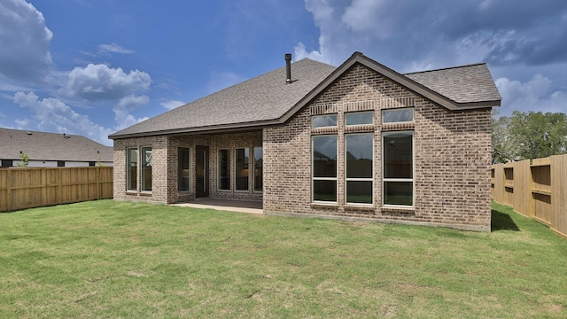 12247 Sweet Gum Dr, Mont Belvieu, TX 77523 - back of property with brick siding, a fenced backyard, roof with shingles, and a patio