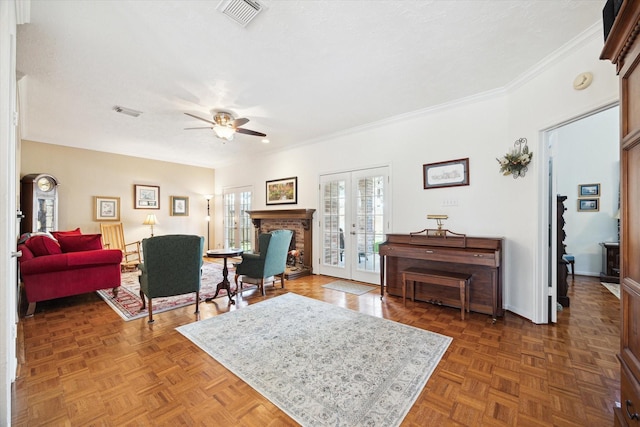 living room with visible vents, a brick fireplace, a ceiling fan, and ornamental molding