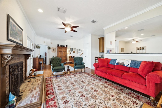 living room with visible vents, crown molding, and ceiling fan