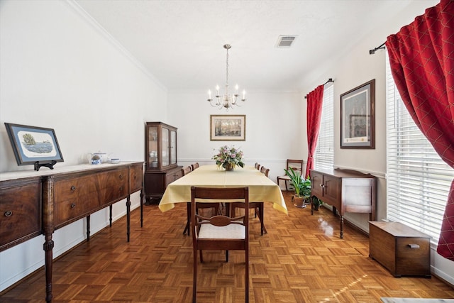 dining area featuring crown molding, visible vents, and a chandelier