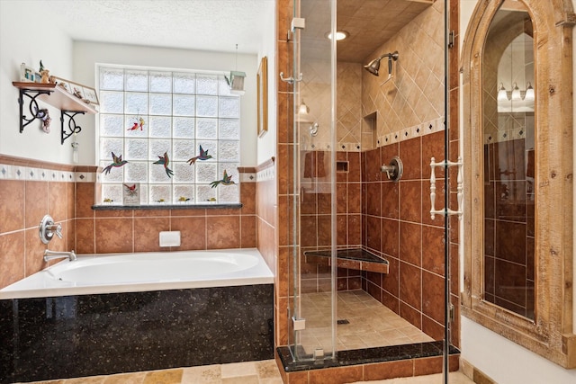 bathroom with a shower stall, a textured ceiling, and a garden tub