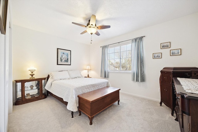 bedroom featuring light colored carpet, baseboards, and ceiling fan