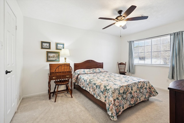 bedroom with a ceiling fan, light colored carpet, and baseboards