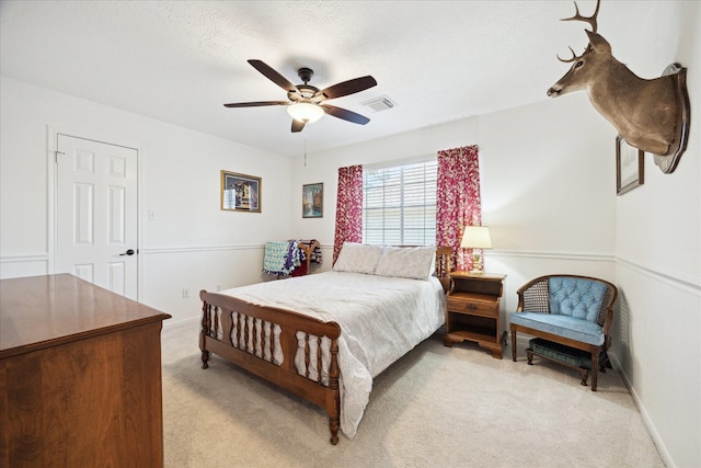 bedroom with ceiling fan, visible vents, and light carpet