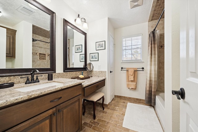 bathroom with visible vents, a textured ceiling, shower / bath combination with curtain, baseboards, and vanity