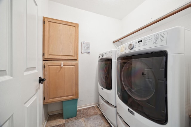 laundry area featuring baseboards, cabinet space, and separate washer and dryer