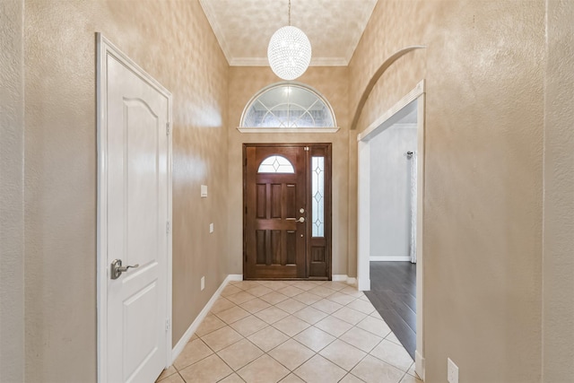 foyer entrance featuring light tile patterned floors, baseboards, and ornamental molding