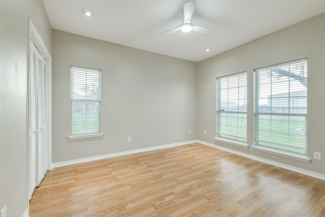 spare room with a ceiling fan, baseboards, and light wood-type flooring