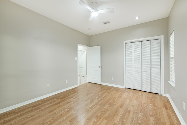 unfurnished bedroom with visible vents, a ceiling fan, a closet, light wood-style floors, and baseboards