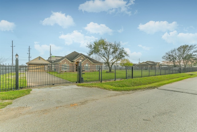 view of gate with a fenced front yard and a yard