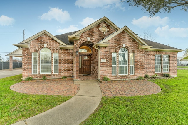 single story home featuring brick siding, roof with shingles, and a front lawn