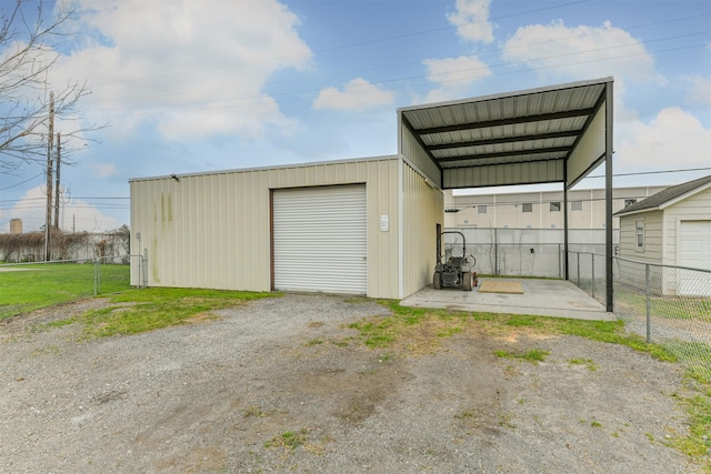 garage with a carport and fence