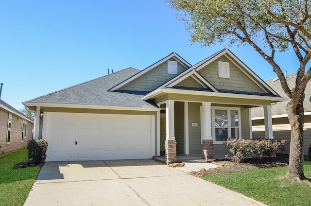 craftsman-style home featuring covered porch, concrete driveway, a garage, and roof with shingles