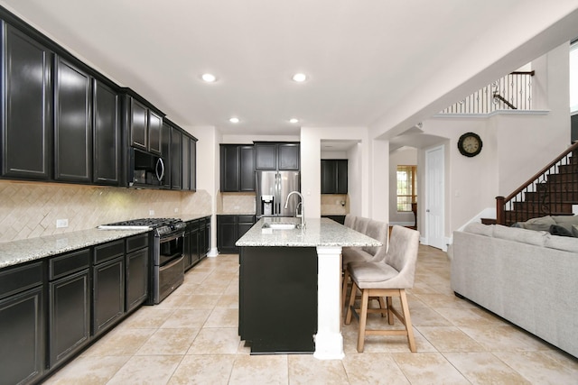 kitchen with range with two ovens, stainless steel fridge with ice dispenser, black microwave, dark cabinets, and backsplash