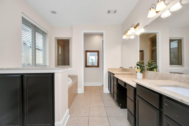 bathroom with tile patterned flooring, visible vents, a garden tub, double vanity, and a sink