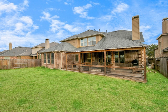 rear view of house featuring roof with shingles, a fenced backyard, a chimney, a lawn, and brick siding