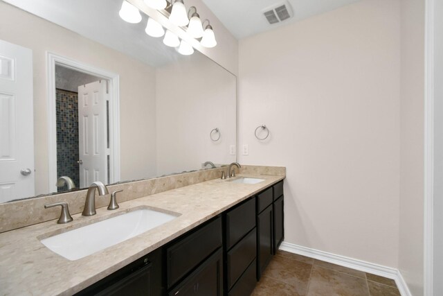 full bath with a sink, visible vents, baseboards, and double vanity