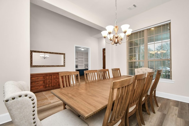 dining room with wood finished floors, visible vents, baseboards, and a chandelier