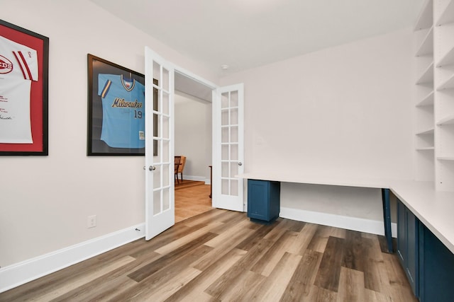 interior space with french doors, baseboards, and wood finished floors