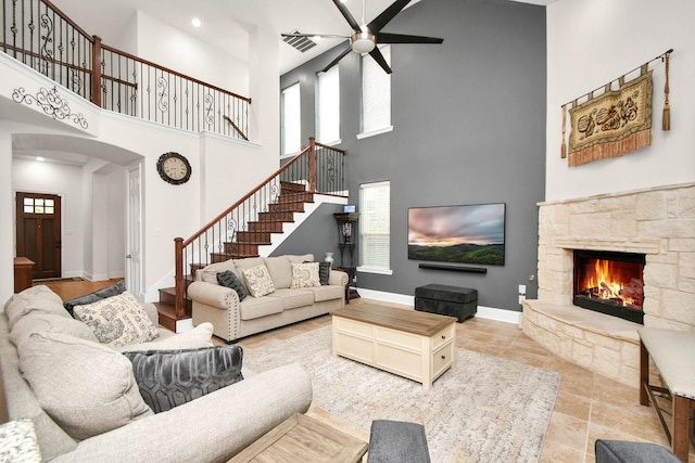 living area with visible vents, baseboards, a fireplace, and stairs