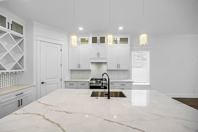 6716 Ave R, Houston, TX 77011 - kitchen featuring a sink, decorative backsplash, decorative light fixtures, white cabinets, and crown molding
