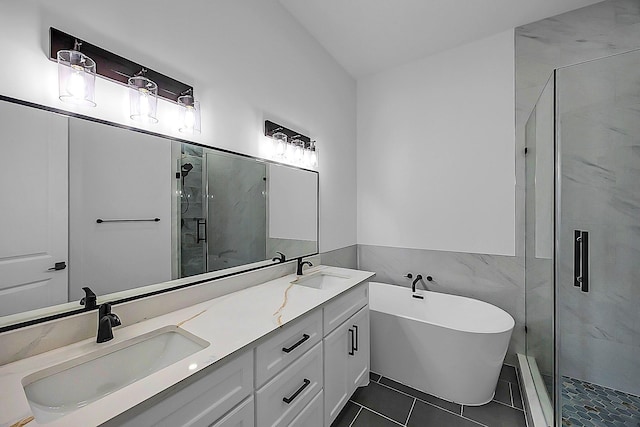 6716 Ave R, Houston, TX 77011 - bathroom featuring a marble finish shower, double vanity, a freestanding tub, tile walls, and tile patterned floors