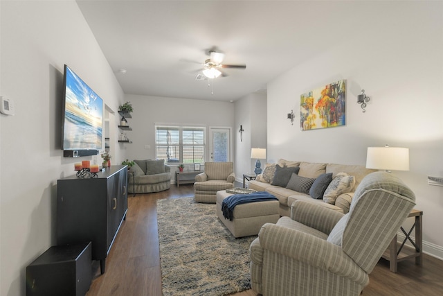 living room with ceiling fan, baseboards, and dark wood finished floors