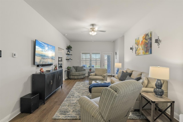 living area featuring ceiling fan, baseboards, and wood finished floors