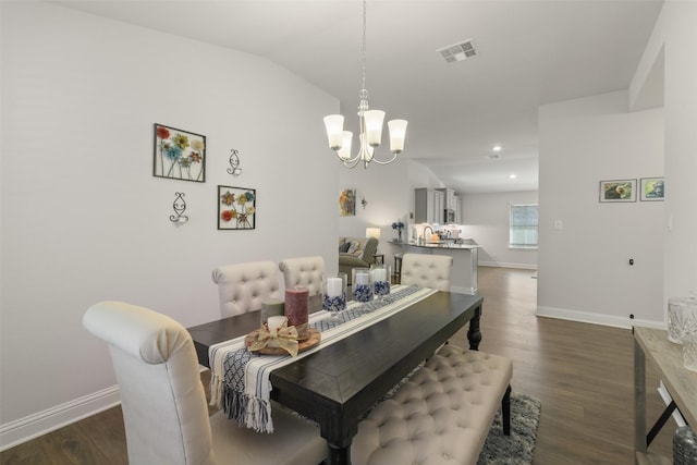 dining area featuring baseboards, visible vents, vaulted ceiling, dark wood-type flooring, and a notable chandelier