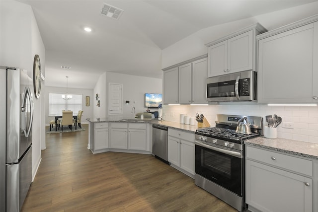 kitchen with visible vents, dark wood-style floors, stainless steel appliances, a peninsula, and lofted ceiling