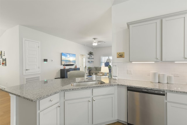 kitchen featuring a ceiling fan, a peninsula, a sink, stainless steel dishwasher, and open floor plan