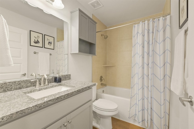 full bath featuring vanity, wood finished floors, visible vents, shower / bath combo with shower curtain, and toilet