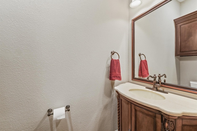 bathroom featuring vanity and a textured wall