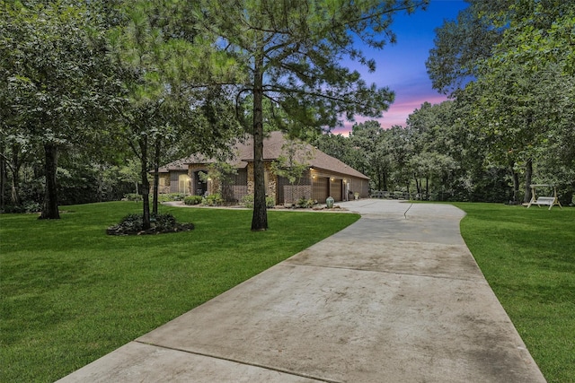 view of front facade featuring a lawn, driveway, and a garage