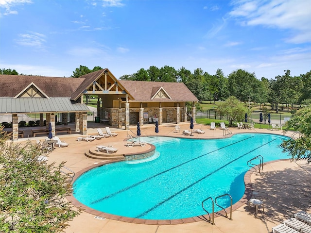 community pool featuring fence and a patio area