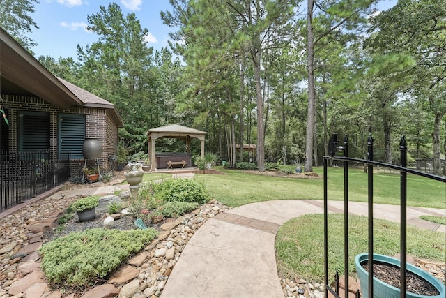 view of yard featuring a gazebo, fence, and a hot tub