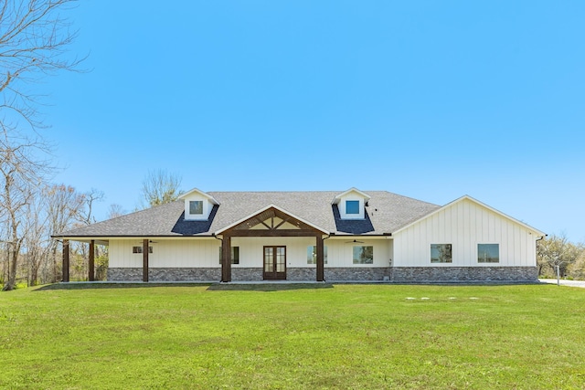 modern farmhouse with french doors, stone siding, a front yard, and a shingled roof