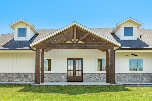 back of property with french doors, brick siding, roof with shingles, and a yard