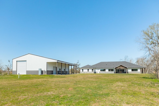 view of yard with a garage, an outbuilding, and a pole building