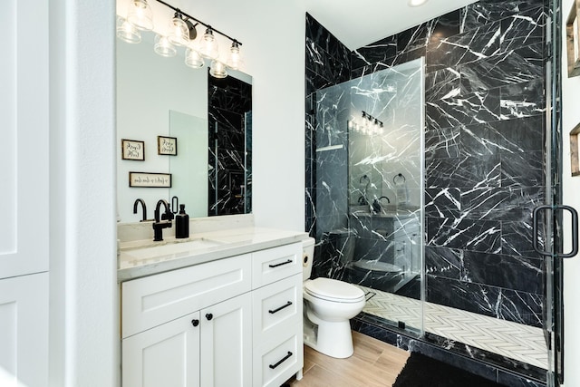 bathroom featuring vanity, toilet, and a marble finish shower