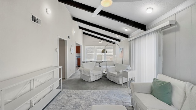 living room with a ceiling fan, visible vents, vaulted ceiling with beams, a textured ceiling, and a decorative wall