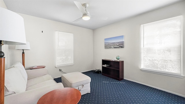 sitting room featuring carpet, baseboards, and ceiling fan