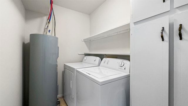 clothes washing area featuring electric water heater, washing machine and dryer, and laundry area