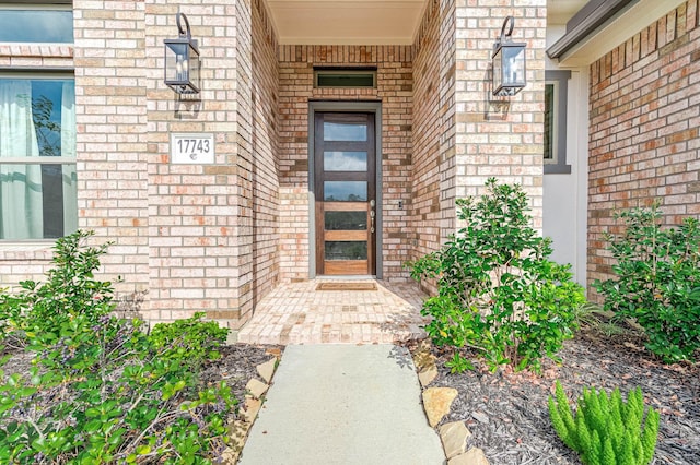 view of exterior entry with brick siding