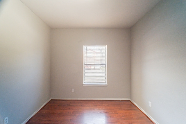 empty room with baseboards and wood finished floors