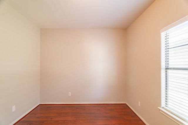 empty room with baseboards and wood finished floors